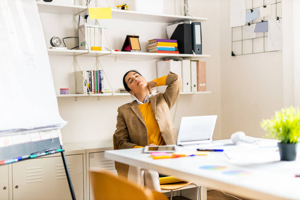 Business company employee working at desk - Entrepreneur with colored smart casual clothes working alone in a start-up office - Photo, image