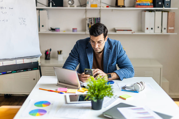 Business company employee working at desk - Entrepreneur with colored smart casual clothes working alone in a start-up office - Фото, изображение