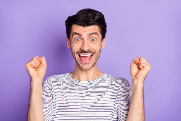 Photo of happy excited smiling crazy man raise fists in victory success screaming isolated on purple color background - Foto, Bild