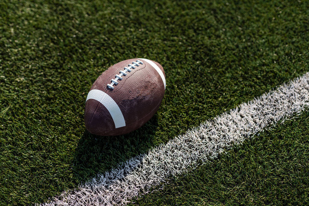 Americký rugby míč na trávě na stadionu - Fotografie, Obrázek