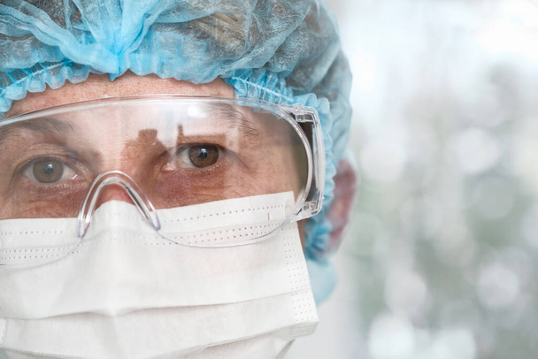 Doctors tired eyes through protective glasses - Fotografie, Obrázek