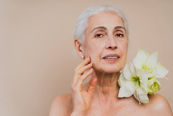 Beautiful senior woman with young and clean look, beauty shot - Pretty senior lady over 60 with perfect skin, concepts about elderly, beauty treatment and skin care - 写真・画像