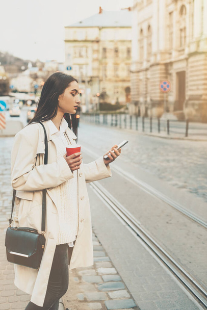 Una donna per strada usa un cellulare. shopping online. utilizzo di applicazioni mobili. - Foto, immagini