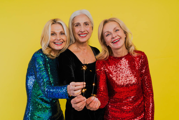 Beautiful senior women with festive elgant dress having fun at a party - Group of sexy mature ladies with eccentric fashionable look poising on clored backgrounds - Concepts about elderly lifestyle - Φωτογραφία, εικόνα