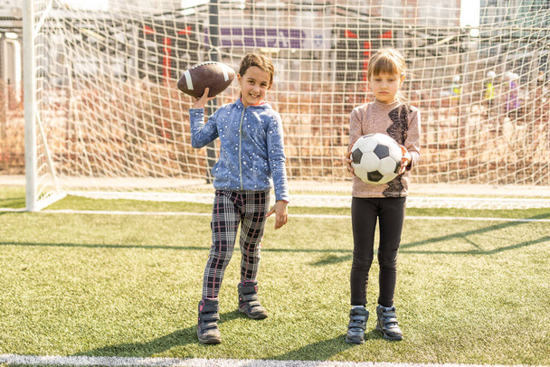 Маленька футбольна команда: дівчатка-малятка з футбольним м'ячем на футбольному полі
. - Фото, зображення