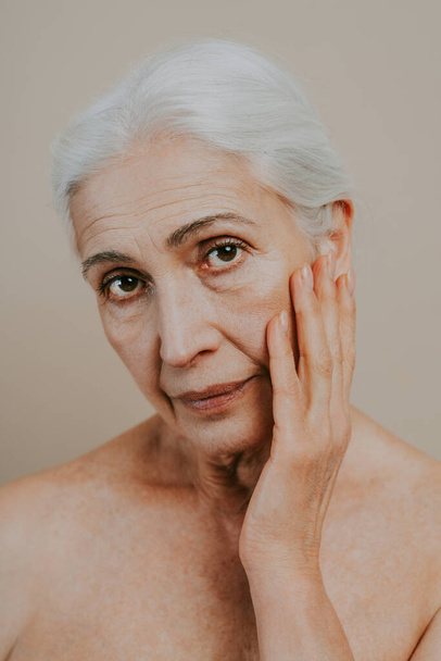 Beautiful senior woman with young and clean look, beauty shot - Pretty senior lady over 60 with perfect skin, concepts about elderly, beauty treatment and skin care - 写真・画像