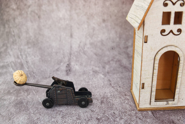 αστείο diorama ενός καταπέλτη, ενώ τραβώντας ένα φιστίκι σε ένα ξύλινο σπίτι - Φωτογραφία, εικόνα