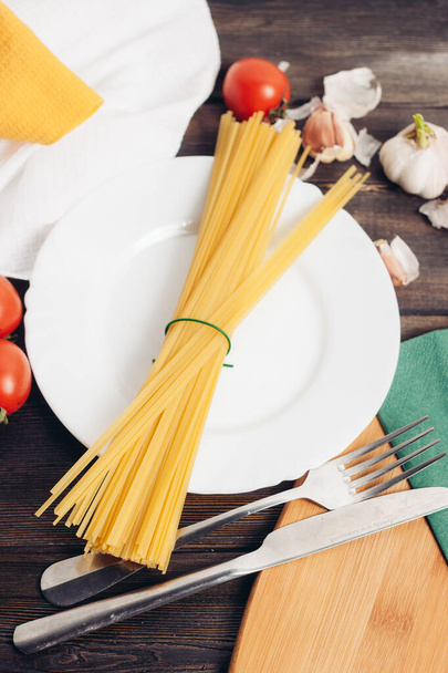 ingrédients pour la fabrication de pâtes italiennes assiette avec ustensiles de cuisine - Photo, image