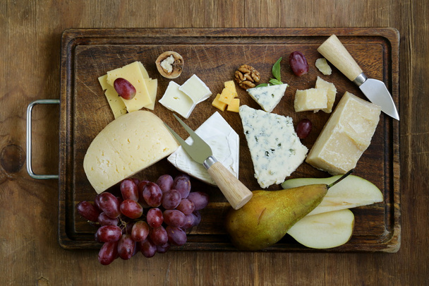 Cheeseboard with assorted cheeses (parmesan, brie, blue, cheddar) - Фото, изображение