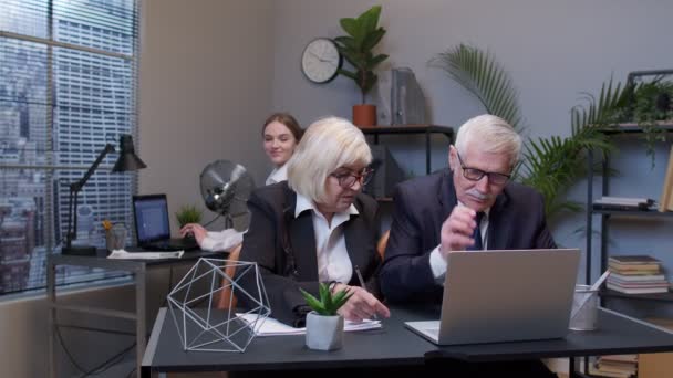 Starší muž šéf s kolegyní pracující v kanceláři, sekretářka relaxace s elektrickým ventilátorem - Záběry, video