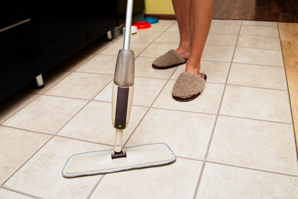 Den Boden mit einem Sprühmopp waschen. Die Hausreinigung ist schnell und einfach, die Dienstleistungen einer Reinigungsfirma. - Foto, Bild