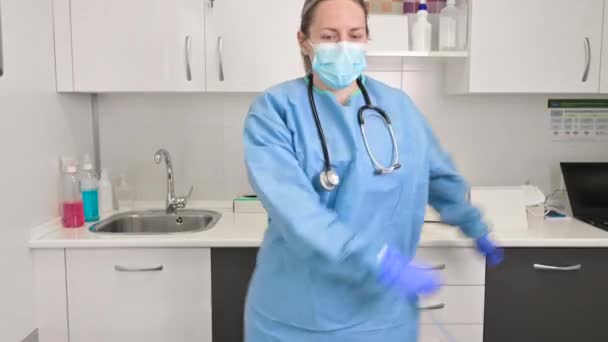 Pozytywna lekarka tańcząca nitkę dentystyczną w szpitalu, świętująca koniec pandemii koronawirusowej. - Materiał filmowy, wideo