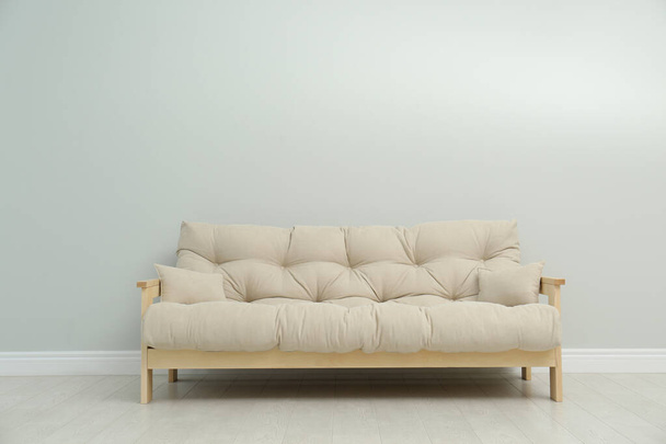 Stylish beige sofa near light wall indoors - Photo, image