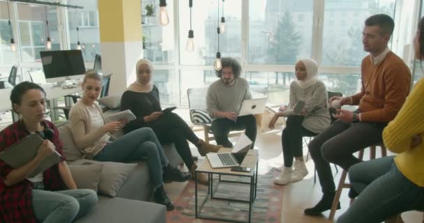 Grupo de compañeros de trabajo multirraciales teniendo una pequeña conversación sobre la siguiente idea para la empresa - Metraje, vídeo