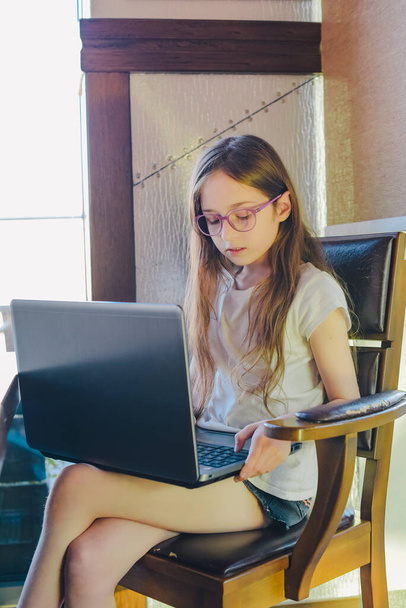 Teini-ikäinen tyttö tietokoneen kotona opettamassa. tietokone, etäopiskelu, tutkimus, webinaari, oppitunti - Valokuva, kuva