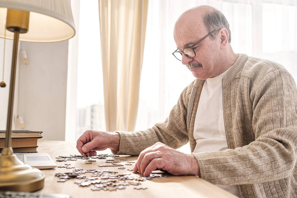 Senior caucasian man working on a puzzle - Photo, Image