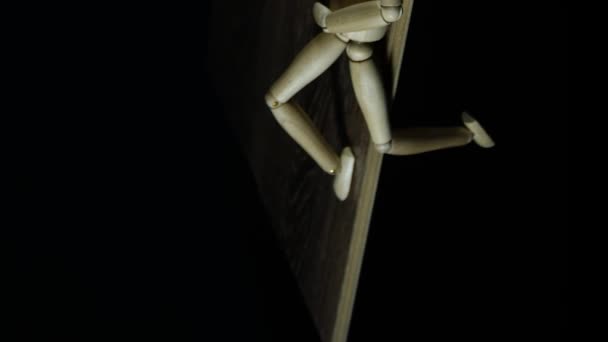 Verticale video Stopbeweging houten figuur dummy vertraagt in studio op zwarte achtergrond leggen en zwaaien benen - Video