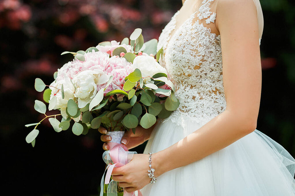 the bride holds the bouquet of flowers in her hand, the wedding floral bouquet - Foto, imagen
