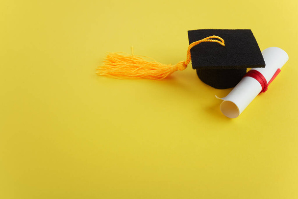 Academic hat with diploma on yellow background. Graduation theme - Foto, Imagem