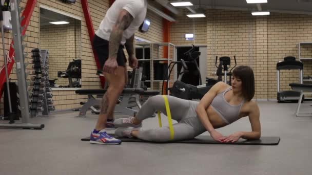Entrenamiento de deportista con instructor personal en gimnasio - Metraje, vídeo