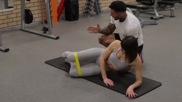 Sportlerin trainiert mit persönlichem Trainer im Fitnessstudio - Filmmaterial, Video