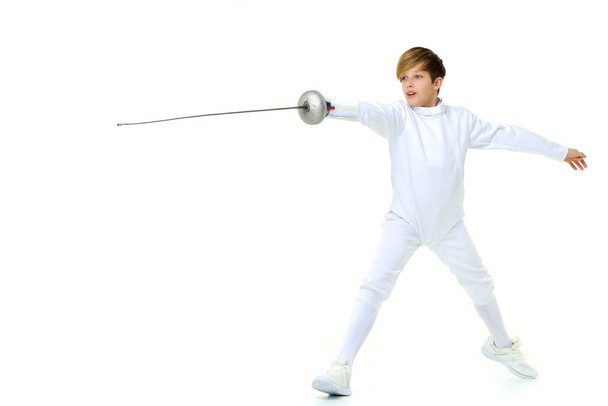 Boy fencer standing in attacking pose. Photo session in the studio - Фото, изображение