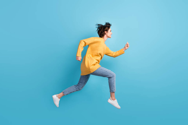 Full length body side profile photo of happy girl running fast jumping high isolated on bright blue color background - Fotoğraf, Görsel