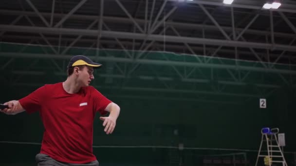 Erwachsener Mann spielt Tennis auf Indoor-Court, schlägt Ball mit Schläger, Profi oder Amateur, Training - Filmmaterial, Video