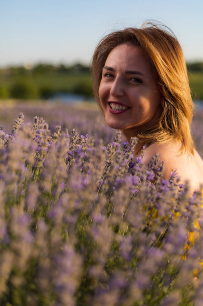 Woman portrait in lavender field. Selective focus, blurred background, toned - Zdjęcie, obraz
