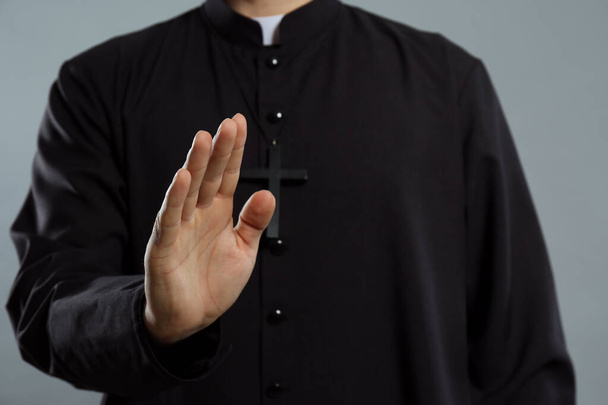 Priest making blessing gesture on grey background, closeup - Photo, image