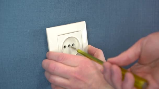 The electrician installs the socket on the wall with a special screwdriver. Close-up. - Footage, Video