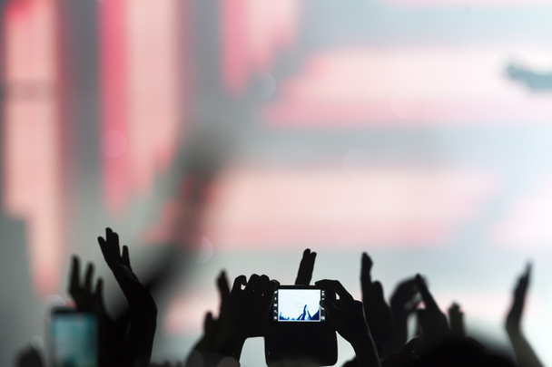 Personas que toman fotografías con un teléfono inteligente táctil durante una música
  - Foto, Imagen