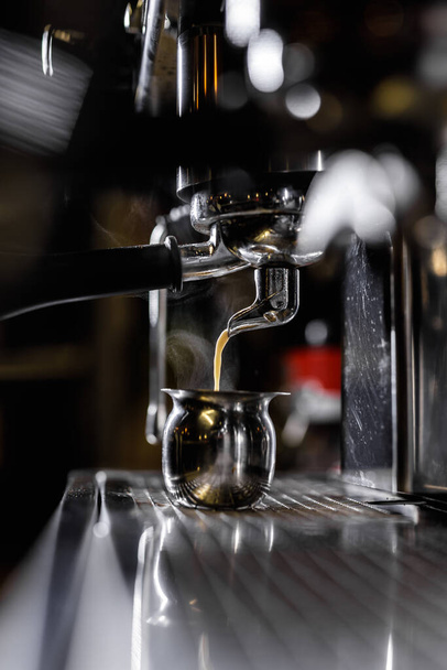 Close-up of professional coffee machine. Pouring espresso. Barista preparing deliciouse fresh hot coffee - 写真・画像