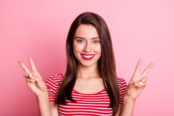 Portrait of young beautiful good mood positive lovely charming girl showing v-sign isolated on pink color background - Foto, Imagen