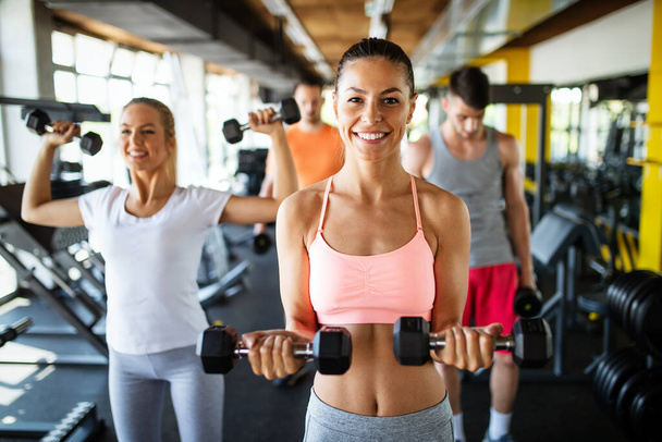 Group of fit young people exercising at the gym. Health, sport, friend, happiness concept - 写真・画像