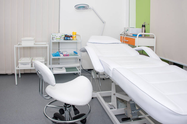Kosmetikschrank mit Massagetisch im modernen Schönheitssalon. Medizinischer Kabinettinnenraum - Foto, Bild