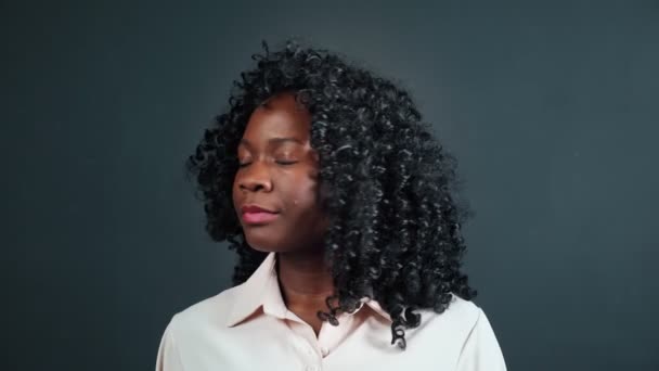 Θετική Αφροαμερικανή γυναίκα γυρίζει και χαμογελάει στα μαύρα - Πλάνα, βίντεο