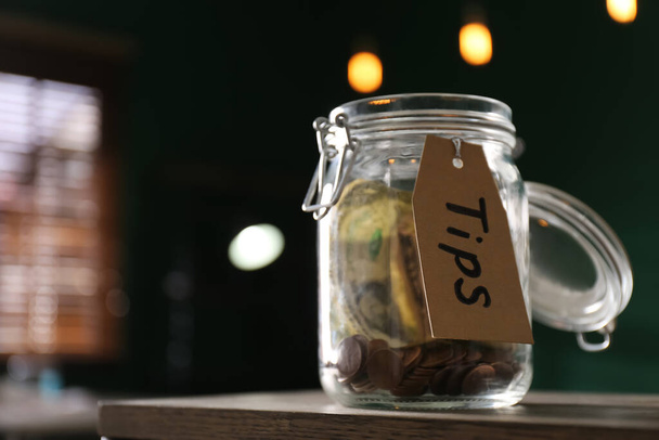 Glass jar with tips on wooden table indoors, closeup. Space for text - Photo, Image