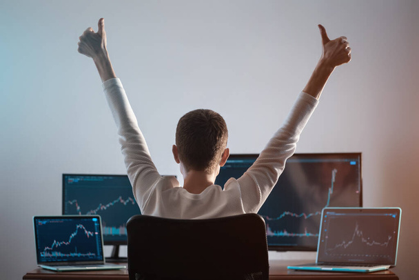 successful male trader looking at monitor with stock exchange graph or chart - Fotoğraf, Görsel
