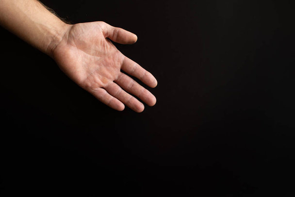 a mans hand on a black background.  - Foto, Imagem