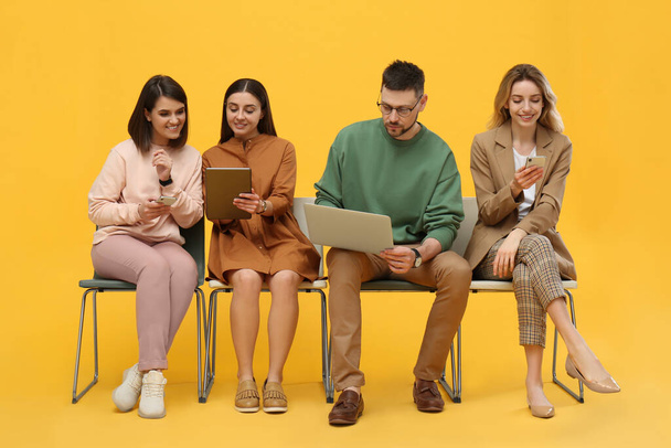 People waiting for job interview on yellow background - Foto, Imagen