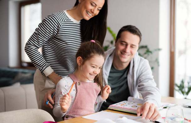 Parents with school girl indoors at home, distance learning and home office. - Valokuva, kuva