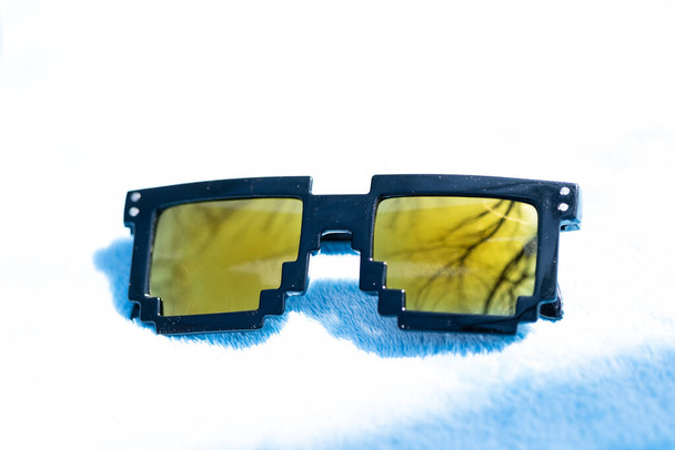 Κίτρινοι φακοί pixel 8bit γυαλιά ηλίου σχεδιασμό πυροβολούν σε ένα κοντινό πλάνο καλοκαιρινής ημέρας.Thug μοντέλο ζωής. Επιλεκτική εστίαση - Φωτογραφία, εικόνα