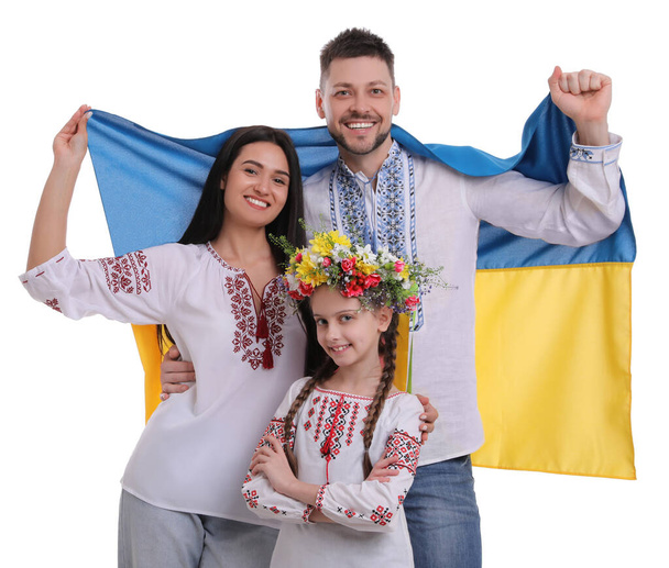 Onnellinen perhe kansallisissa vaatteissa lipun Ukrainan valkoisella taustalla - Valokuva, kuva