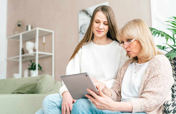 Mother and adult daughter using digital tablet - Photo, Image