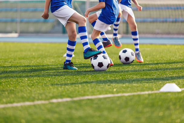 Ноги футболістів вбивають м'ячі на тренувальному майданчику. Футбольний футбол фону. Футбольна практика для школярів
 - Фото, зображення