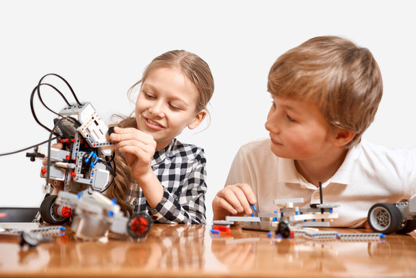Young friends creating robot using building kit. - Photo, image