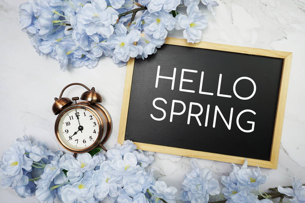 Hello Spring text on wooden blackboard and flower decoration on marble background - Fotografie, Obrázek