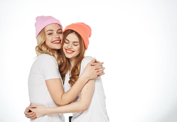 two girlfriends hugging together communication lifestyle fun light background - Photo, Image