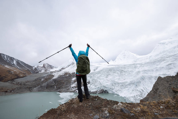 Successful woman backpacker celebrating on winter high altitude mountain top - Fotografie, Obrázek
